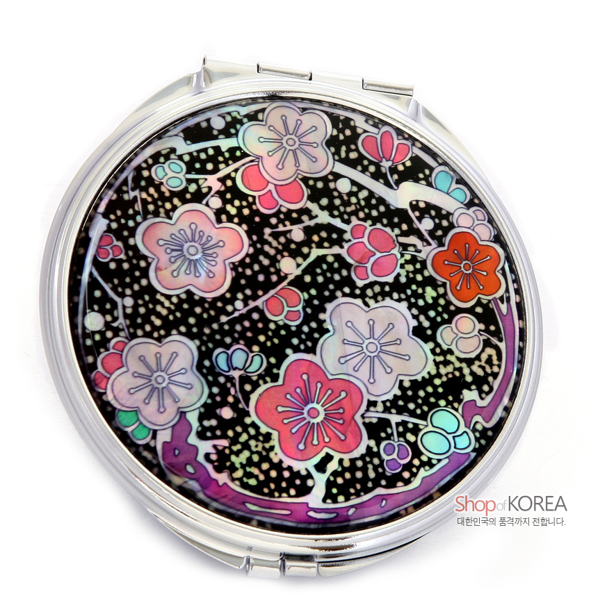 [텍스트: Shop of KOREA 대한민국의 품격까지 전합니다.] 금속 테두리에 흑색 바탕과 자개 상감 기법으로 표현된 다채로운 색매화 문양 원형 손거울 디자인