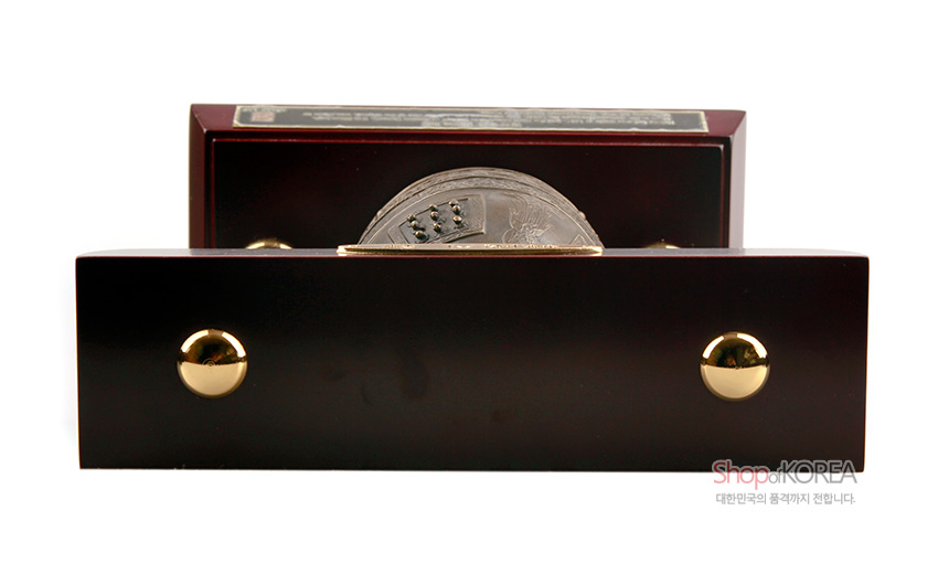[텍스트: ShopofKOREA 대한민국의 품격까지 전합니다] 짙은 갈색 목재 받침대와 금속 해인사 동종 모형, 전면 금빛 금속 장식 포인트 구성