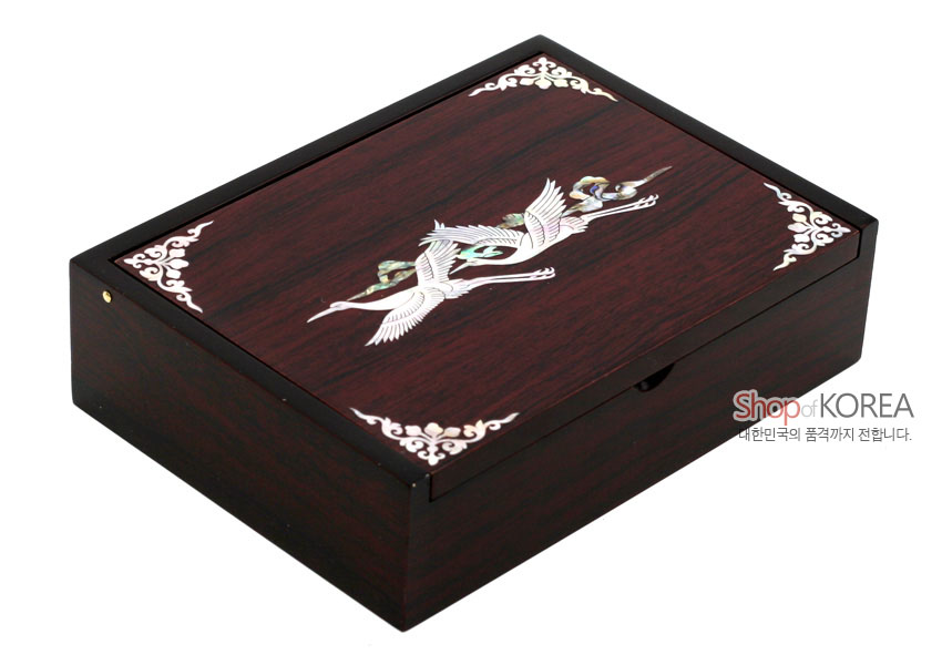 [텍스트: Shop of KOREA 대한민국의 품격까지 전합니다.] 짙은 갈색 옻칠 목재 위 자개 상감 구름과 학 문양, 모서리 백색 운문 장식 직사각 명함함 디자인