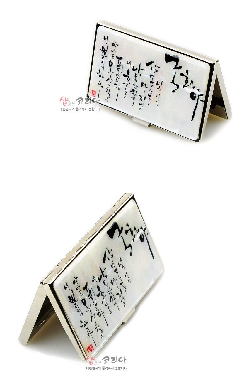 [텍스트: 샵오브코리아 / 대한민국의 품격까지 전합니다] 흰 천연 자개 바탕 위에 먹색 한글 시구가 상감된 금속 프레임 명함집 디자인