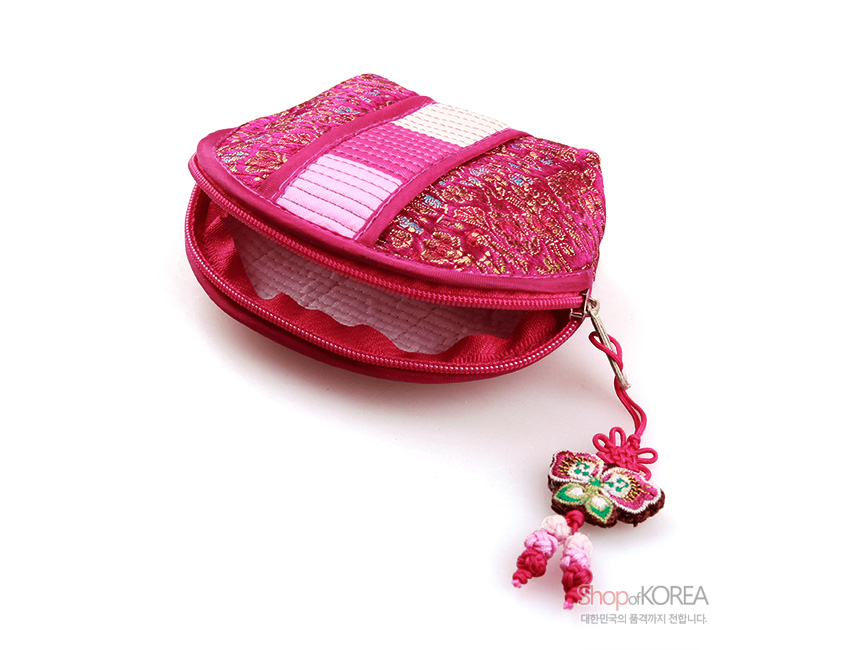 [텍스트: ShopofKOREA 대한민국의 품격까지 전합니다.] 분홍색 비단 누비 바탕에 금사 꽃문양과 색동띠가 조화를 이루고, 나비 모양 자수 매듭 장식이 달린 동전지갑 디자인