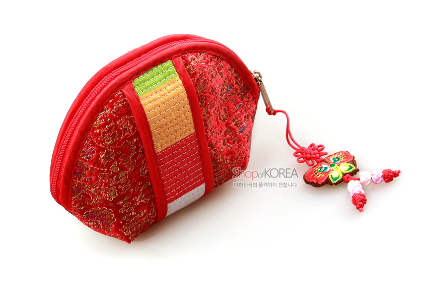 [텍스트: Shop of KOREA 대한민국의 품격까지 전합니다] 붉은 비단에 금색 전통문양을 넣고 누비 기법의 색동띠와 나비 모양 매듭술 장식을 더한 반달형 동전지갑 모습
