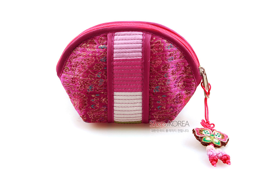 [텍스트: ShopofKOREA 대한민국의 품격까지 전합니다.] 분홍색 비단 누비 바탕에 색동띠 장식과 꽃문양 자수, 나비 매듭 술 장식이 돋보이는 반달형 동전지갑 디자인