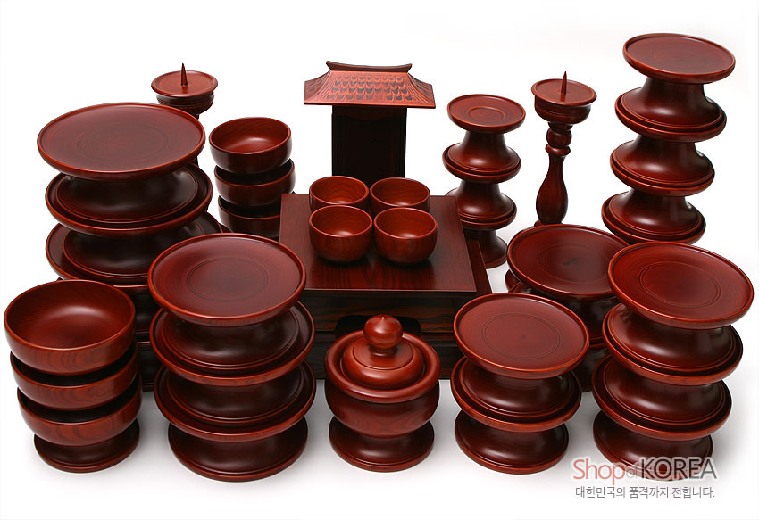 [텍스트: Shop of KOREA 대한민국의 품격까지 전합니다.] 붉은 갈색 옻칠 마감 물푸레나무 제기 37조 세트, 다양한 높이의 접시와 그릇·향로·촛대로 구성된 전통 제사용 목기 세트 이미지 설명