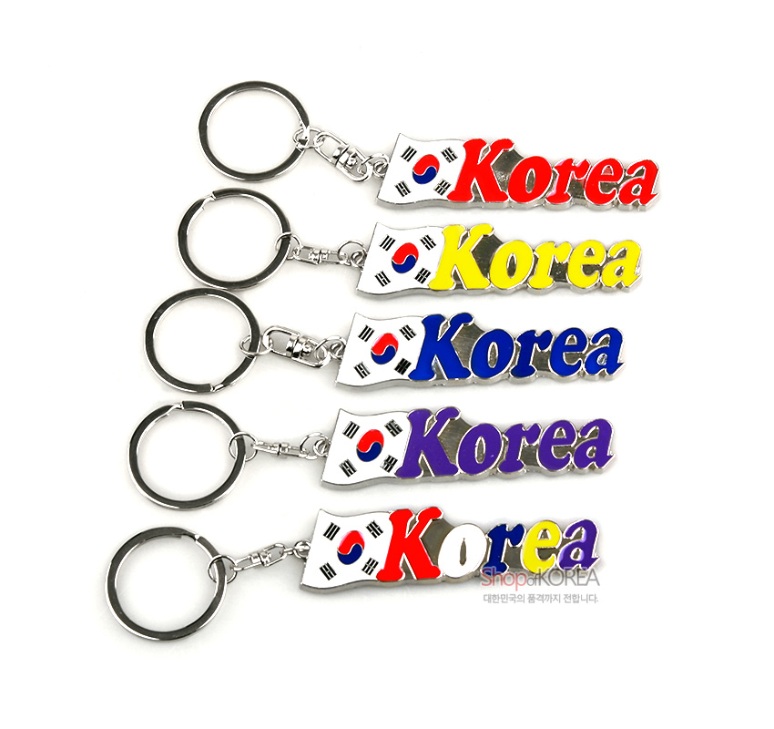 [텍스트: Korea] 금속 재질 태극기 문양 판 위에 빨강·노랑·파랑·보라 등 다양한 색상의 영문 레터링이 입체적으로 채색된 열쇠고리 구성
