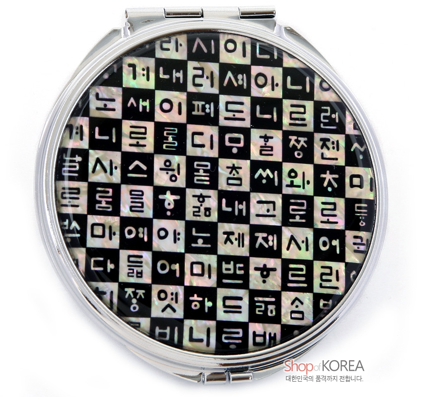 [텍스트: Shop of KOREA 대한민국의 품격까지 전합니다.] 흑색 바탕에 자개 상감 기법으로 훈민정음 자모를 격자무늬로 배열한 원형 금속 손거울 디자인