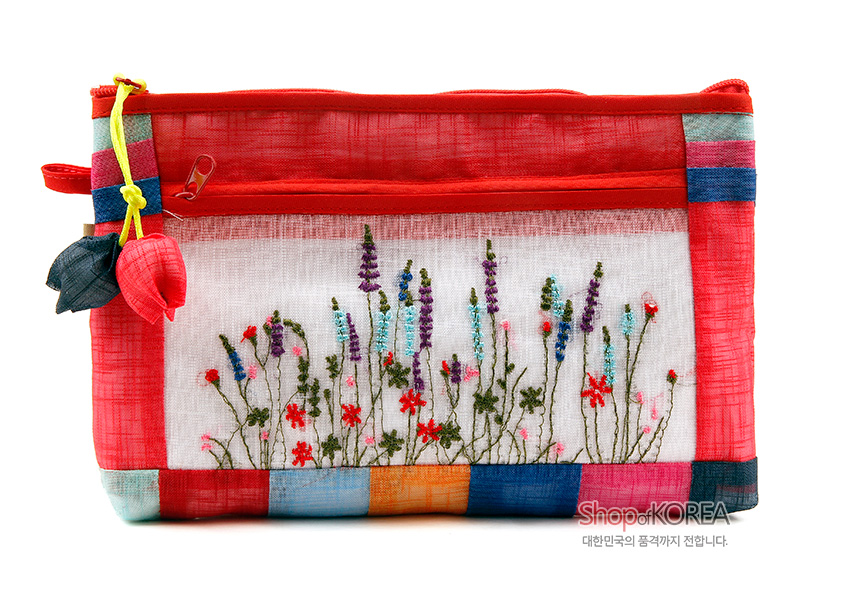 [텍스트: Shop of KOREA 대한민국의 품격까지 전합니다.] 붉은 모시 바탕에 색동 배색 가장자리와 전면 야생화 자수 장식, 꽃 매듭 장식이 달린 지퍼형 파우치 디자인
