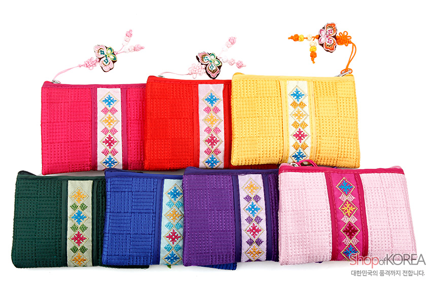 [텍스트: Shop of KOREA, 대한민국의 품격까지 전달합니다.] 다양한 색상의 누비 비단 재질 동전지갑, 중앙 전통 기하학 자수 띠와 나비 매듭 장식 구성