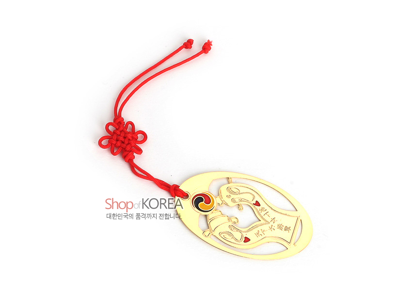 [텍스트: Shop of KOREA 대한민국의 품격까지 전합니다] 금장 처리된 타원형 금속 책갈피에 장승 문양과 한자 음각, 태극 문양 장식, 붉은 전통 매듭 끈이 어우러진 디자인
