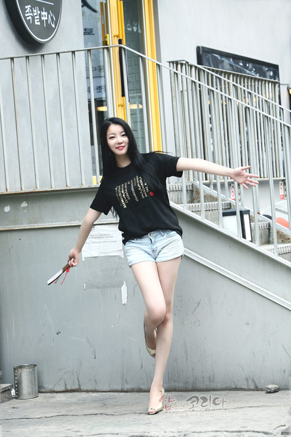 [텍스트: 족발센터] 검은색 면 티셔츠에 금색 입체 발포 기법으로 표현된 훈민정음 한글 서체와 붉은 포인트 장식이 있는 반소매 디자인 이미지 설명