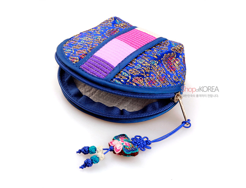 [텍스트: ShopofKOREA 대한민국의 품격까지 전합니다.] 감색 비단 바탕에 금색 전통 문양과 분홍·보라 색동 누비 장식, 나비 모양 자수 매듭 고리를 더한 동전지갑 모습