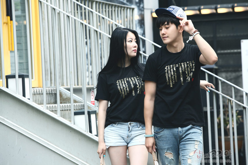 [텍스트: 훈민정음] 검은색 면 티셔츠 위에 금색 입체 발포 기법으로 표현된 훈민정음 한글 문양이 돋보이는 캐주얼 반소매 디자인