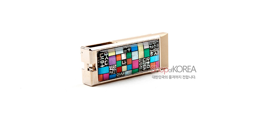 [텍스트: Shop of KOREA 대한민국의 품격까지 전합니다.] 금속 USB 본체에 훈민정음 글자와 다채로운 색상의 조각보 격자 문양이 상감된 디자인 모습