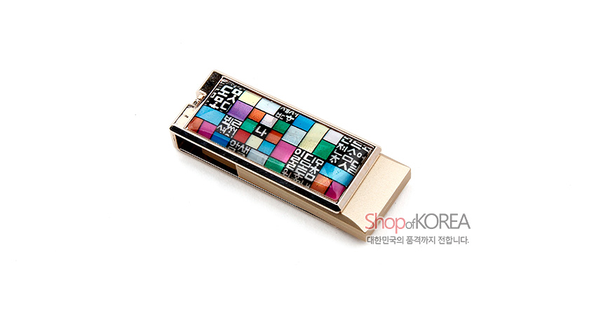 [텍스트: Shop of KOREA, 대한민국의 품격까지 전합니다.] 금속 재질 USB 본체에 훈민정음 글자와 오방색 조각보 패턴이 상감된 직사각형 장식 디자인