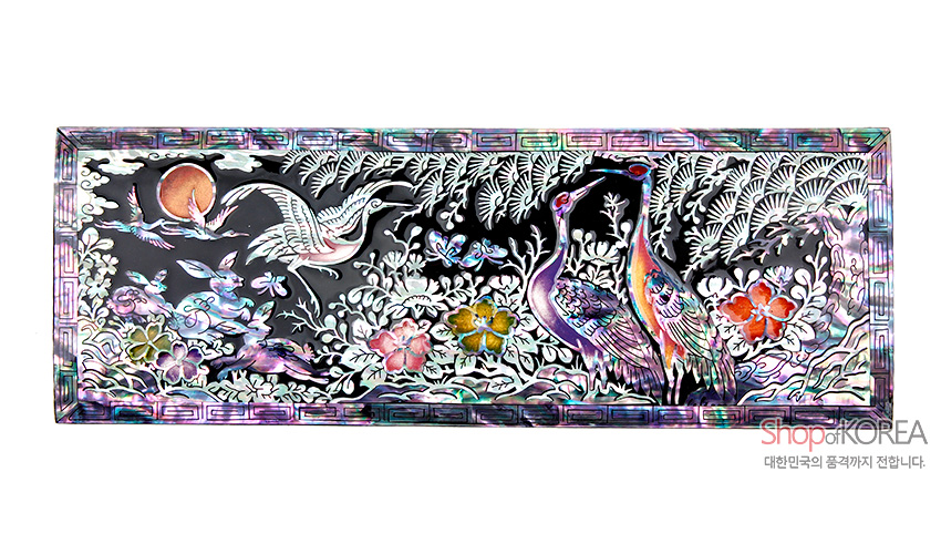 [텍스트: Shop of KOREA 대한민국의 품격까지 전합니다.] 흑색 옻칠 바탕 위 자개 상감 기법으로 해와 구름, 소나무와 학, 꽃무늬를 오색으로 표현한 사각 필함 상단 장식 이미지