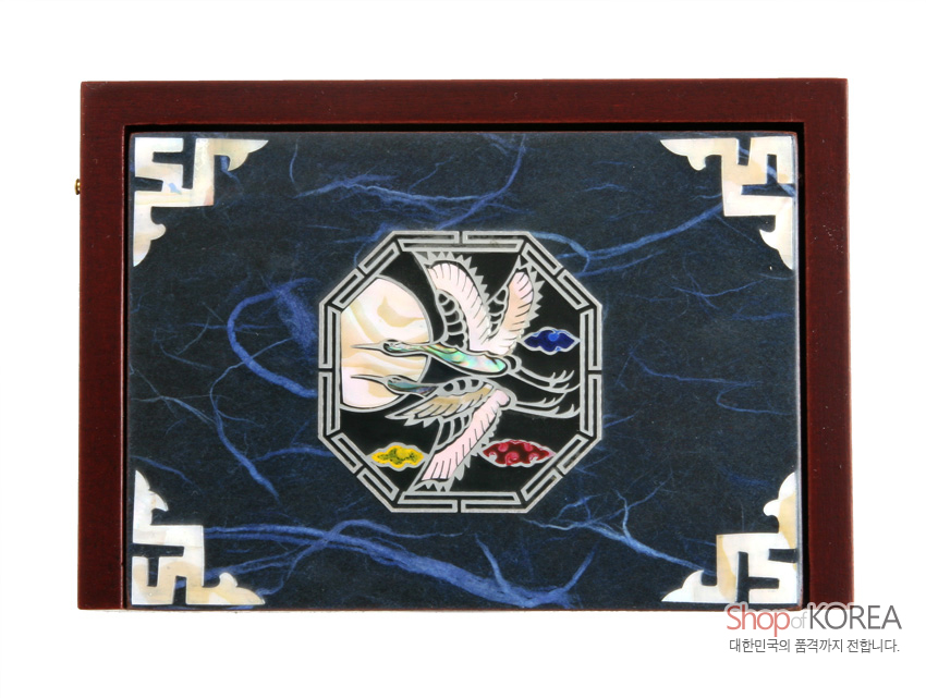 [텍스트: Shop of KOREA 대한민국의 품격까지 전합니다.] 짙은 청색 한지 위 팔각 구도 속 학과 구름 자개 상감, 모서리 백색 전통 기하학 문양이 어우러진 나무 명함함 상판 모습