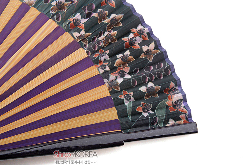 [텍스트: Shop of KOREA 대한민국의 품격까지 전합니다.] 자색과 황색이 교차된 살과 짙은 녹색 실크 면 위에 도라지꽃과 잎사귀 문양이 섬세하게 인쇄된 전통 접이식 부채 디자인