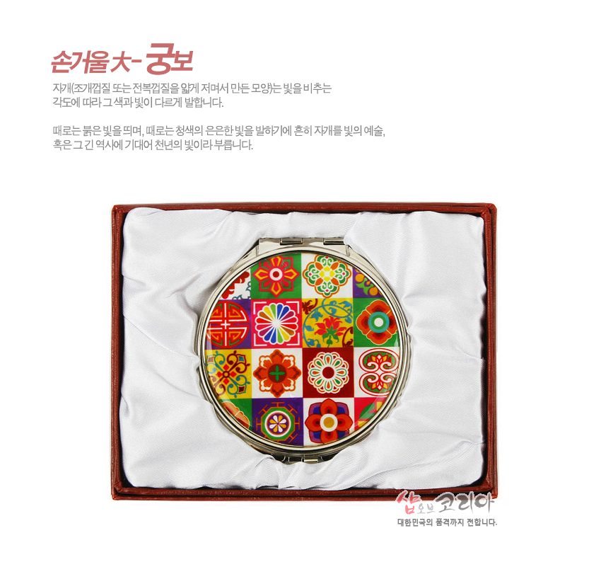 [텍스트: 손거울大-궁보] 금속 테두리 위 자개 기법 느낌의 다채로운 단청색 전통 꽃문양과 기하학 문양이 격자 형태로 배열된 원형 손거울 디자인