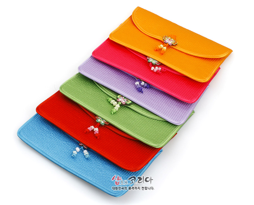 [텍스트: 샵오브코리아 대한민국의 품격까지 전합니다.] 다채로운 색상의 누비 비단 원단으로 제작된 장지갑들, 곡선형 플랩과 중앙의 전통 나비매듭 장식이 돋보이는 구성