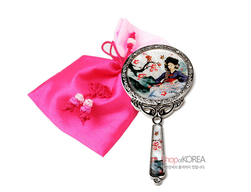 [텍스트: Shop of KOREA, 대한민국의 품격까지 전합니다.] 자개로 황진이 인물화와 매화·나비 문양을 장식한 금속 손거울, 분홍 비단 주머니와 매듭 장식 구성