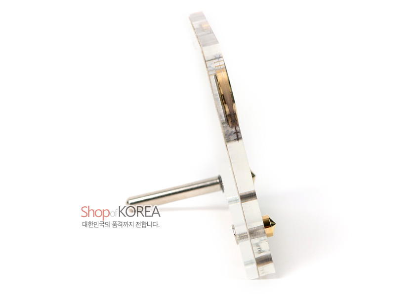[텍스트: Shop of KOREA 대한민국의 품격까지 전합니다.] 자개 느낌 투명 판에 금속 지지대로 세운 슬림한 측면 디자인의 탁상용 시계 모습