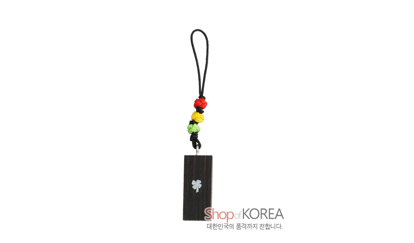 [텍스트: Shop of KOREA 대한민국의 품격까지 전달합니다.] 흑단 직사각 펜던트에 자개 운학 문양을 상감하고 오방색 매듭 장식과 검은끈을 더한 핸드폰고리 형식의 열쇠고리 디자인