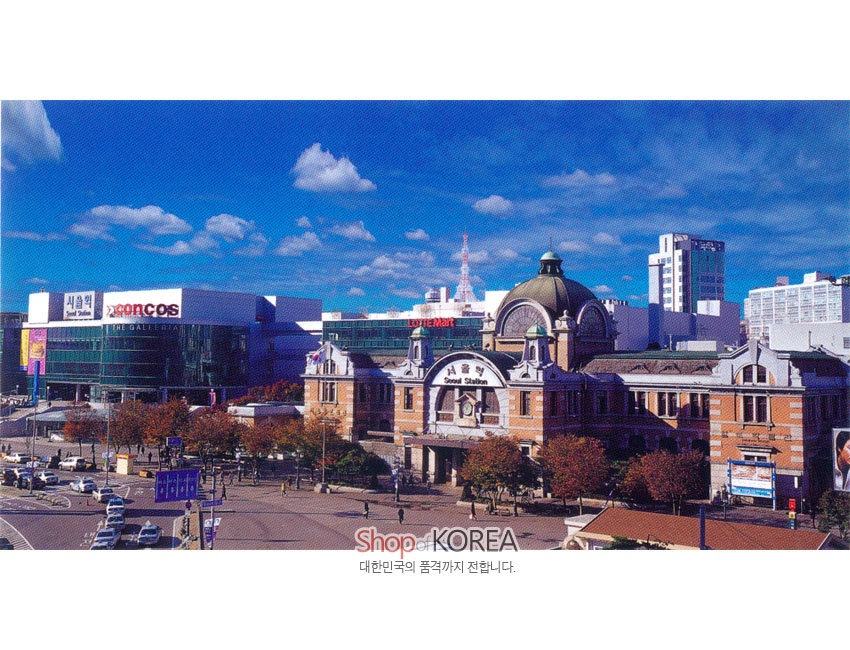 [텍스트: 서울역 Seoul Station / LOTTE Mart / Shop of KOREA 대한민국의 품격까지 전합니다.] 푸른 하늘 아래 고전 양식 붉은 벽돌 서울역과 현대식 상가 건물이 대비되는 직사각형 풍경 사진엽서 이미지