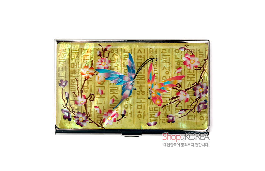 [텍스트: Shop of KOREA 대한민국의 품격까지 전합니다.] 황금빛 금속 바탕 위 훈민정음 문자와 오색 자개 나비·매화 가지 문양이 상감된 명함케이스 디자인