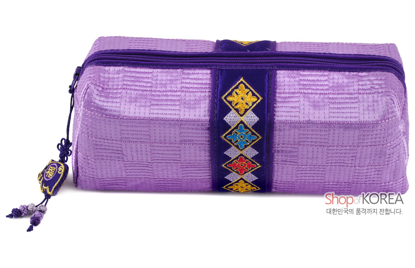 [텍스트: Shop of KOREA, 대한민국의 품격까지 전합니다.] 보라색 누비 비단으로 제작된 직사각형 필통, 중앙의 자주색 띠 위 다채로운 전통 자수 문양과 옆면 복자 장식 매듭이 돋보이는 디자인