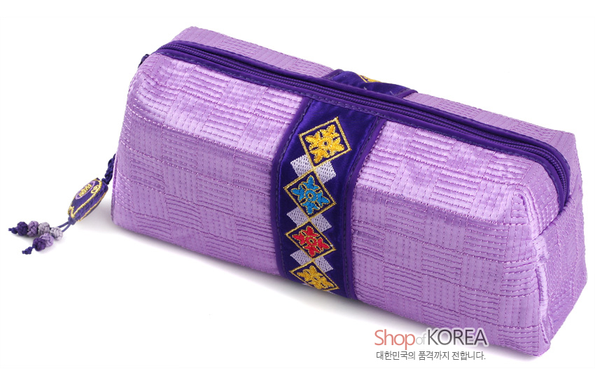 [텍스트: Shop of KOREA 대한민국의 품격까지 전합니다.] 자색 누비 비단으로 제작된 직사각형 필통, 중앙에 보라색 띠와 다색 자수 복문양 장식, 옆면에 복돼지 매듭 장식 포인트 디자인