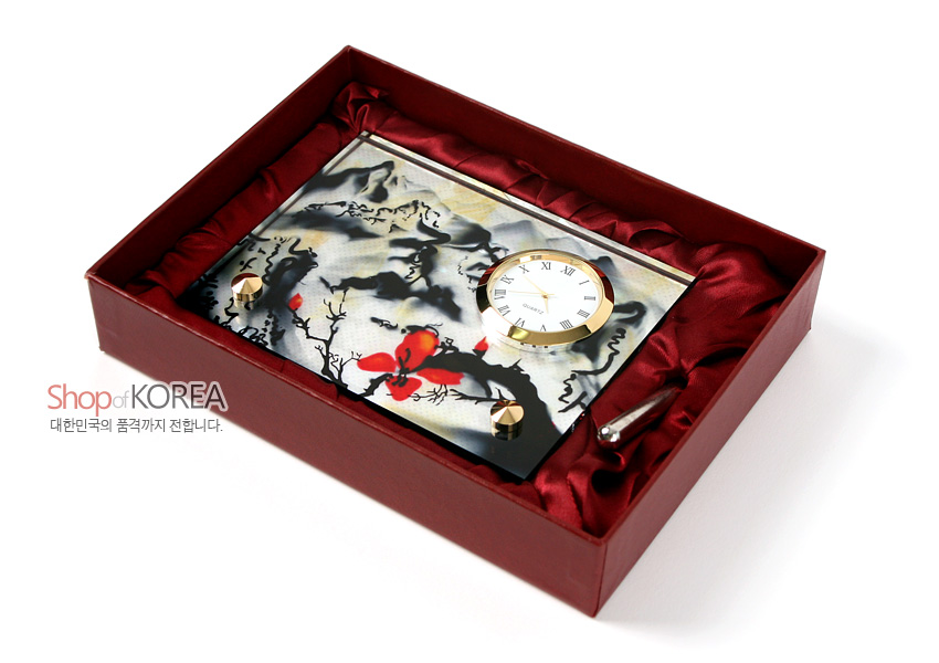 [텍스트: Shop of KOREA 대한민국의 품격까지 전합니다.] 자개 느낌의 광택 판 위에 수묵 산수와 붉은 꽃 문양을 채색한 직사각형 금속 테두리 원형 시계 장식