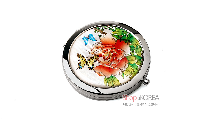 [텍스트: Shop of KOREA / 대한민국의 품격까지 전합니다.] 자개 바탕 위에 붉은 목단꽃과 파란 나비, 노랑 나비, 녹색 잎을 섬세한 채색으로 담은 원형 금속 손거울 디자인