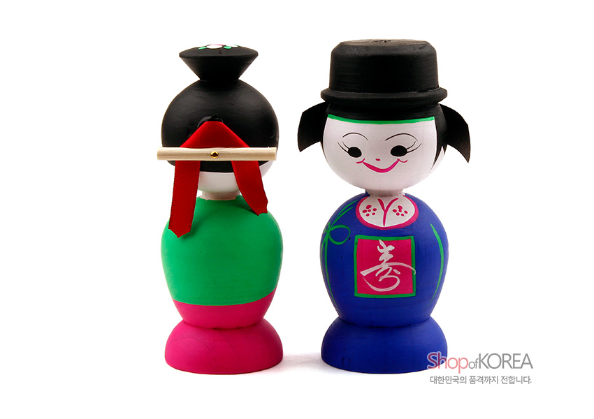 [텍스트: Shop of KOREA, 대한민국의 품격까지 전합니다.] 강렬한 청색·녹색·분홍 채색의 나무 혼례인형, 한복과 전통 갓·족두리 표현한 단순한 선과 도안형 문양 장식 모습