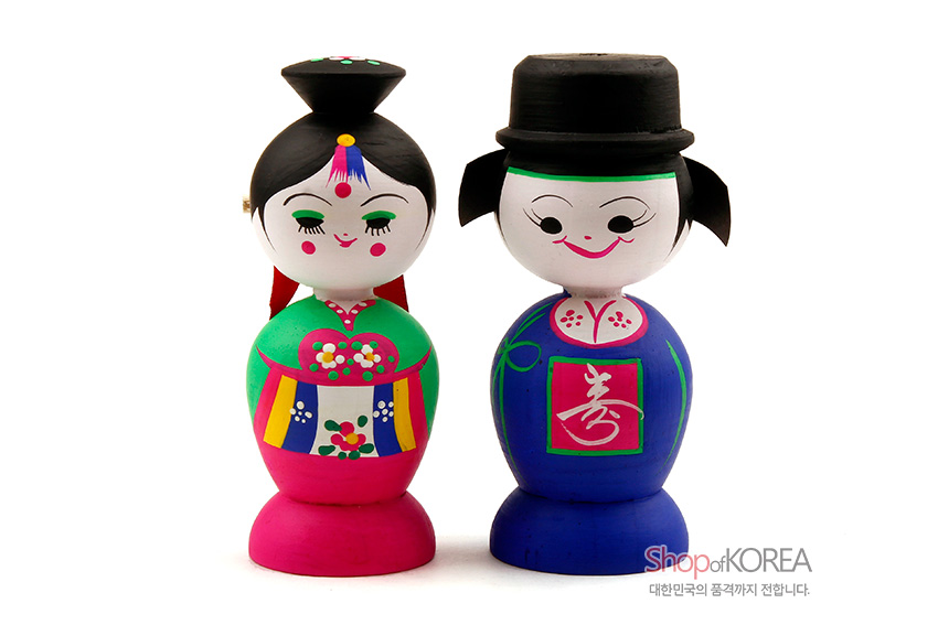 [텍스트: Shop of KOREA, 대한민국의 품격까지 전합니다.] 원목 재질 위 채색 기법 사용, 화려한 녹색·분홍·파랑 색상과 꽃·수字 문양이 강조된 한복 혼례 목각 인형 쌍 모습