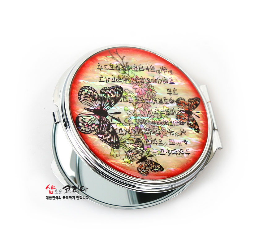 [텍스트: 훈민정음 서문 일부] 붉은 그러데이션 자개 배경 위 나전 상감 기법의 나비와 꽃문양이 장식된 금속 양면 손거울 디자인
