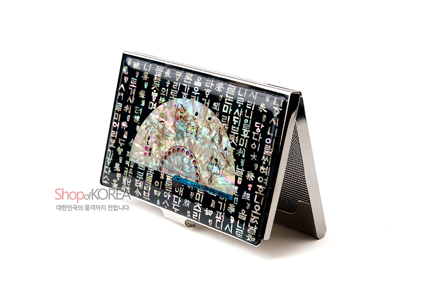 [텍스트: Shop of KOREA 대한민국의 품격까지 전합니다.] 검은 바탕 위 자개 상감 훈민정음 문자와 오색 자개 부채 문양이 장식된 금속 명함집 모습