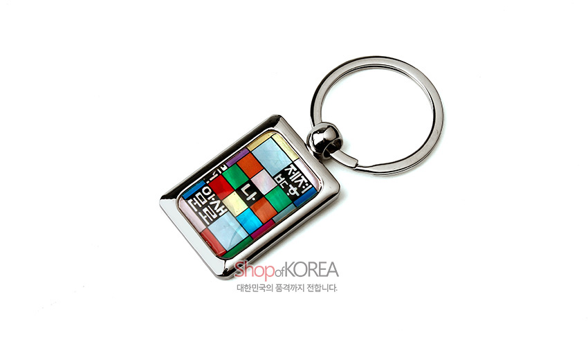 [텍스트: SHOPofKOREA 대한민국의 품격까지 전달합니다.] 금속 프레임 안 자개 조각보 기법으로 다채로운 색면을 배치하고, 흰색 훈민정음 자모 문양을 상감한 직사각형 열쇠고리 디자인