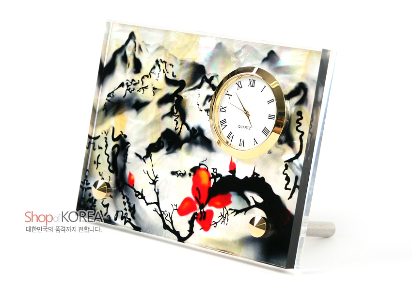 [텍스트: Shop of KOREA / 대한민국의 품격까지 전합니다.] 자개 바탕에 수묵 산수도와 붉은 꽃 문양을 채색한 직사각형 패널, 금속 테두리 원형 아날로그 시계 결합 탁상용 장식 시계