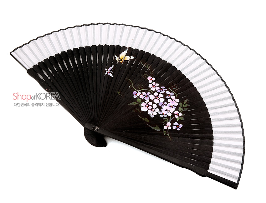 [텍스트: Shop of KOREA 대한민국의 품격까지 전달합니다.] 검은 비단 살과 흰 종이 배경에 분홍 매화와 노랑 나비를 수채화풍으로 수공 채색한 전통 접이식 부채 디자인