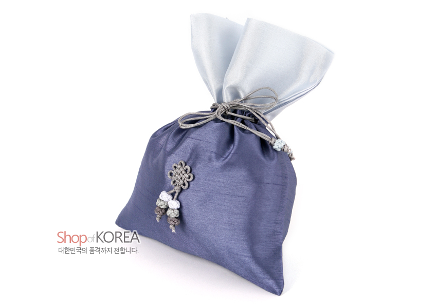 [텍스트: Shop of KOREA 대한민국의 품격까지 전합니다.] 보라빛 비단 소재에 연회색 비단 안감과 회색 끈 매듭 장식, 하단 복주머니형 매듭술이 조화를 이룬 전통 매듭주머니 형태의 주머니형 공예품