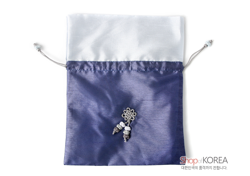 [텍스트: Shop of KOREA 대한민국의 품격까지 전합니다.] 은은한 광택의 보랏빛 비단과 흰 비단이 배색된 복주머니, 중앙 은회색 전통 매듭과 구슬 술 장식 포인트