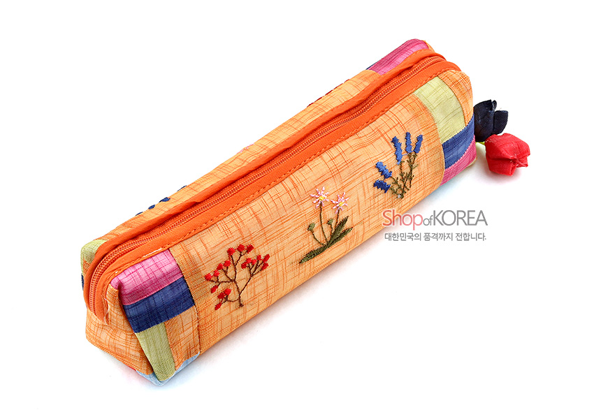 [텍스트: Shop of KOREA / 대한민국의 품격까지 전합니다.] 황색 모시 바탕에 꽃자수와 색동 조각천 배색, 꽃봉오리 매듭 장식이 더해진 필통 디자인