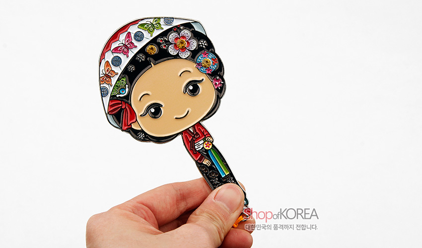 [텍스트: Shop of KOREA 대한민국의 품격까지 전합니다.] 금속 재질 위 채색 기법으로 표현한 한복 어우동 캐릭터 손거울, 화려한 꽃과 나비 문양, 오방색 노리개 장식이 돋보이는 디자인