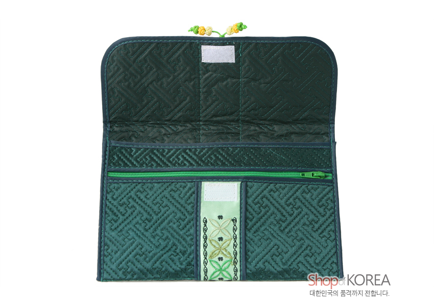 [텍스트: Shop of KOREA 대한민국의 품격까지 전합니다.] 진녹색 비단 누비 바탕에 아(亞)자 전통 기하문 누빔과 연두색 수자수 띠, 매듭 장식이 조화로운 여권·통장 지갑 내부 구성