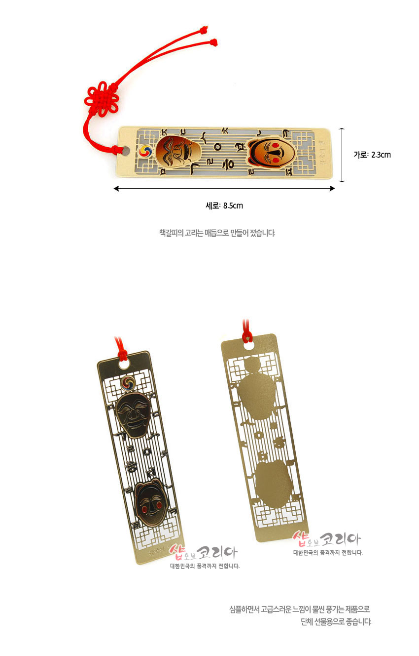 [텍스트: KUMKANG KOREA, 세로: 8.5cm, 가로: 2.3cm, 책갈피의 고리는 매듭으로 만들어 졌습니다.] 금속 재질 바탕에 금장 전통 창살무늬와 하회탈 문양, 상단 태극 상징, 붉은색 전통 매듭 끈 장식 디자인