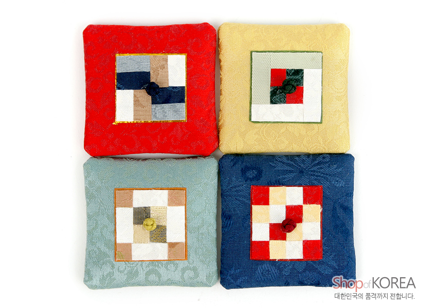 [텍스트: Shop of KOREA 대한민국의 품격까지 전합니다.] 비단 소재 사각 보자기 위 전통 조각보 누비 기법의 패치워크와 중앙 연봉매듭 장식이 어우러진 자석 장식 이미지