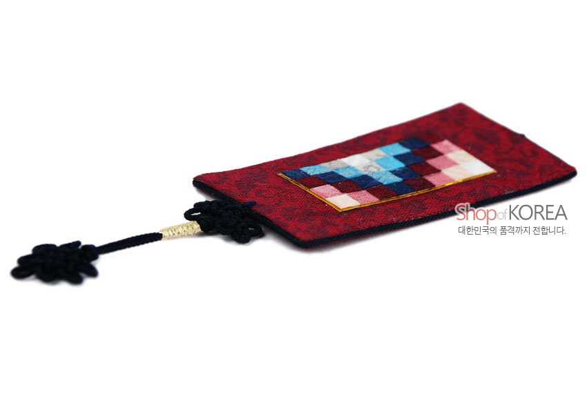 [텍스트: Shop of KOREA 대한민국의 품격까지 전합니다.] 자주색 비단 바탕에 분홍·남색·하늘색 조각보 누비 장식과 검은 전통 매듭 술이 달린 직사각형 책갈피형 공예품