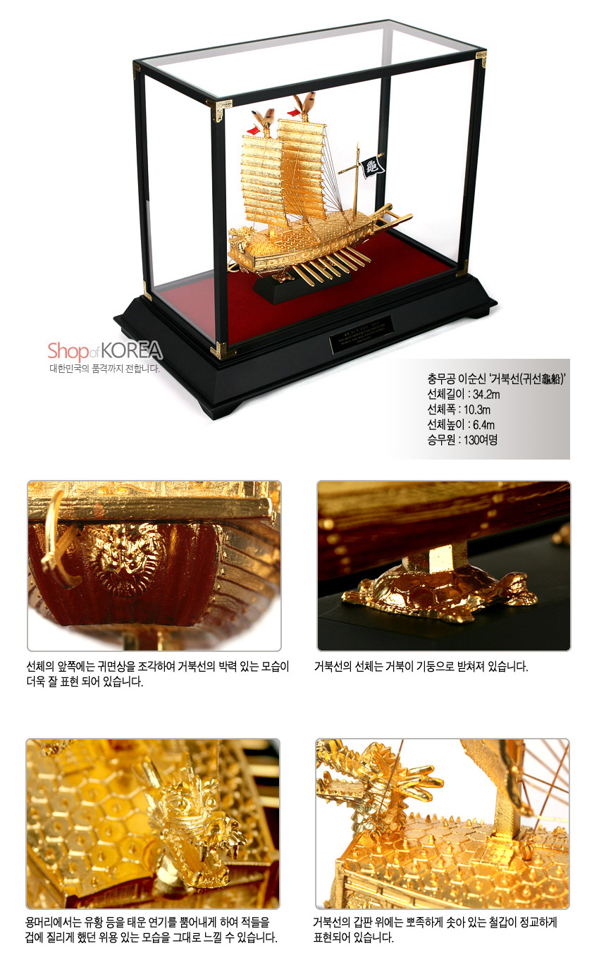 [텍스트: Shop of KOREA 대한민국의 품격까지 전합니다. 충무공 이순신 '거북선(龜船龜船)' 선체길이 : 34.2m 선체폭 : 10.3m 선체높이 : 6.4m 승무원 : 130여명] 유리 쇼케이스 안 금속 재질 24K 도금 거북선 모형과 용두, 거북 기둥, 철갑 문양, 붉은 받침대의 대비가 돋보이는 장식 구성