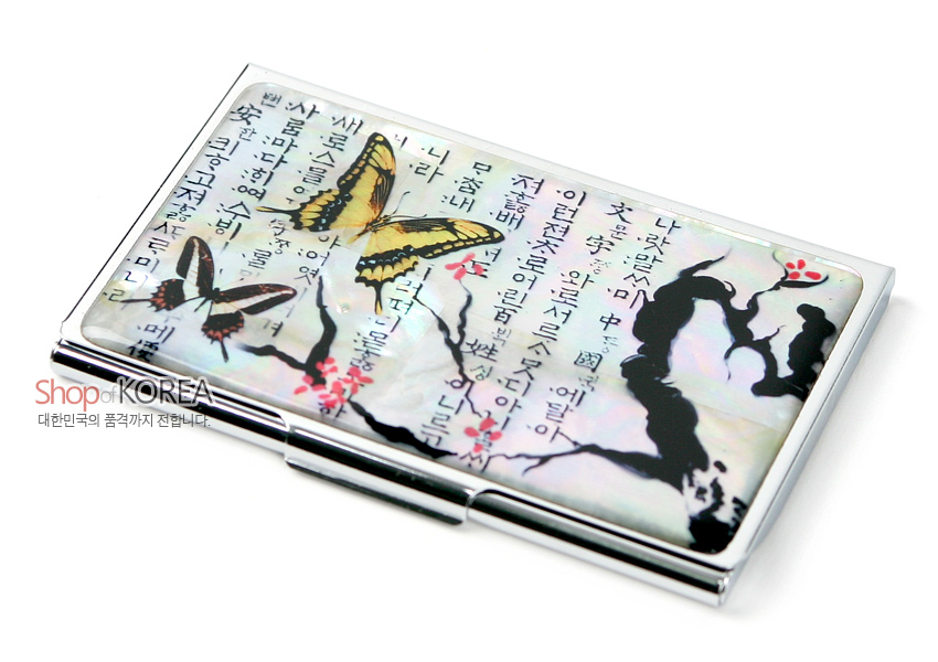 [텍스트: Shop of KOREA 대한민국의 품격까지 전달합니다.] 자개 바탕 위 한글 서예문과 매화 가지, 노랑·갈색 나비 문양이 어우러진 금속 명함케이스 디자인