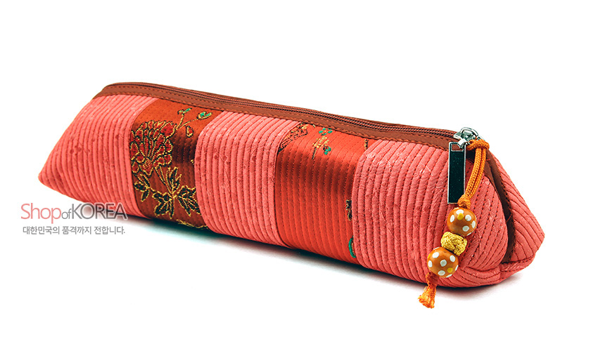 [텍스트: Shop of KOREA 대한민국의 품격까지 전달합니다.] 분홍·주황색 누비 비단 패치워크와 꽃 자수 문양, 지퍼와 구슬 장식이 어우러진 삼각형 필통 형태의 누비띠 필통 이미지 설명